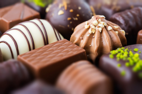 Selección de bombones y chocolates variados en primer plano, ideales para un capricho elegante en glamping.