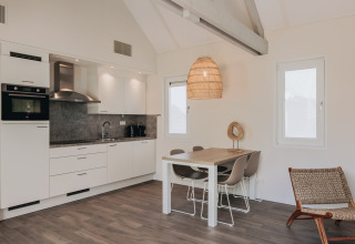 Moderne køkken og spisestue på Beach Resort Nieuwvliet-Bad 16 i Nederlandene med stilfuldt interiør.