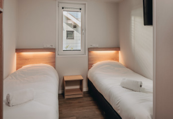 Dos camas individuales con ropa de cama blanca en una habitación del Beach Resort Nieuwvliet-Bad 16 en Países Bajos.