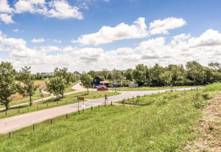 Uitzicht op plattelandsweg bij Beach Resort Nieuwvliet-Bad 16 in Nederland met groen landschap.