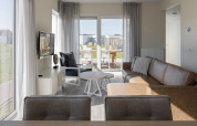 Sala luminosa en Beach Resort Nieuwvliet-Bad 14, Países Bajos, con sofá, televisor y vista a la terraza.