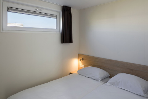 Lyst og enkelt værelse på Beach Resort Nieuwvliet-Bad 14 med to enkeltsenge og lille vindue.