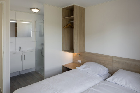 Moderne lodge på Beach Resort Nieuwvliet-Bad 14 med to enkeltsenge og eget badeværelse i Holland.