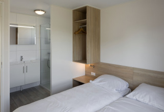 Moderne lodge på Beach Resort Nieuwvliet-Bad 14 med to enkeltsenge og eget badeværelse i Holland.