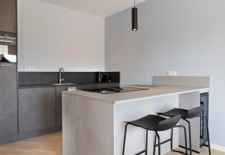 Cucina moderna al Resort Nieuwvliet-Bad 13 nei Paesi Bassi con ampio bancone e sgabelli minimalisti.