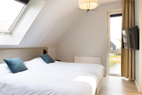 Camera moderna con lucernario, letto matrimoniale e vista panoramica a Resort Nieuwvliet-Bad 13.