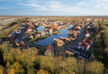 Aerial view of Resort Nieuwvliet-Bad 13 in the Netherlands showing lakes, lodges, and scenic greenery.