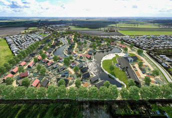 Aerial view of Resort Nieuwvliet-Bad 13 in the Netherlands, showing cottages, lakes and open fields around.