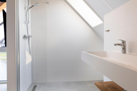 Bagno moderno al Resort Nieuwvliet-Bad 13 nei Paesi Bassi con doccia, lavabo e soffitto inclinato.