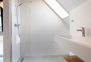Bagno moderno al Resort Nieuwvliet-Bad 13 nei Paesi Bassi con doccia, lavabo e soffitto inclinato.