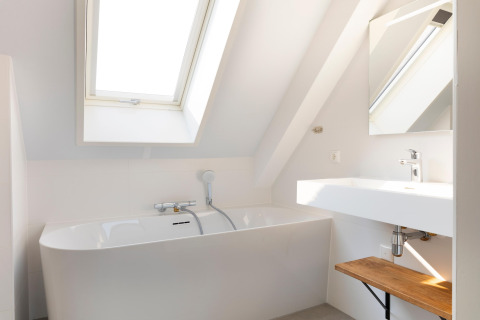 Bagno moderno al Resort Nieuwvliet-Bad 13 nei Paesi Bassi con vasca da bagno, lavandino e lucernario.