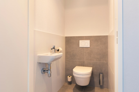 Bagno moderno e minimalista con wc sospeso e piccolo lavabo al Resort Nieuwvliet-Bad 13 nei Paesi Bassi.