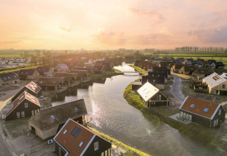 Vista aerea del Resort Nieuwvliet-Bad 13 nei Paesi Bassi, lodge sui canali al tramonto.