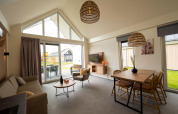 Moderne opholdsstue med højt til loftet og store vinduer i en lodge på Holiday Park Zeebad 14, Holland.