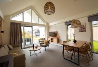 Modern living space with large windows and cozy decor at Holiday Park Zeebad 14 lodge in the Netherlands.