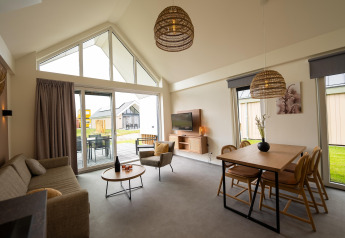 Modern living space with large windows and cozy decor at Holiday Park Zeebad 14 lodge in the Netherlands.