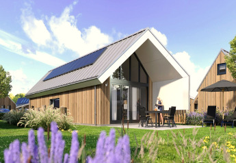 Moderne lodge med solpaneler i ferielandsbyen Zeebad 14, Holland, omgivet af grønne planter og blå himmel.