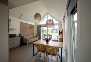 Séjour moderne et coin repas à la maison Holiday Park Zeebad 14 aux Pays-Bas, avec lumière naturelle.