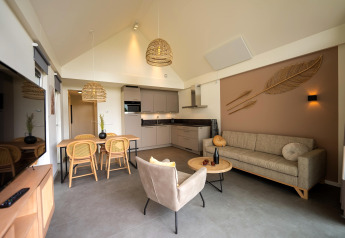 Modern living room and kitchen at Holiday Park Zeebad 14 lodge in the Netherlands with stylish natural decor.