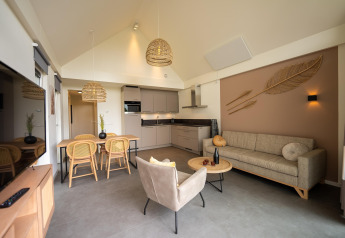 Modern living room and kitchen at Holiday Park Zeebad 14 lodge in the Netherlands with stylish natural decor.