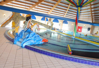 Indendørs swimmingpool på Holiday Park Zeebad med farverige dekorationer og børnevenlige faciliteter.