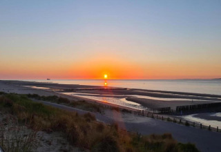 Atardecer en la playa visto desde Holiday Park Zeebad 14 en los Países Bajos, paisaje tranquilo y sereno.