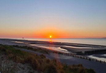 Atardecer en la playa visto desde Holiday Park Zeebad 14 en los Países Bajos, paisaje tranquilo y sereno.