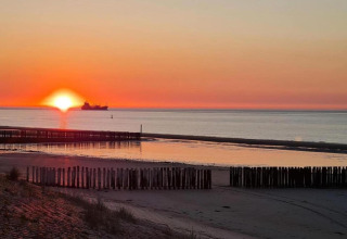 Tramonto sul mare dal Holiday Park Zeebad 14 nei Paesi Bassi, con una nave all’orizzonte.