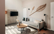Moderne stue i Holiday Park Zeebad 11, Nederlandene, med lys sofa, TV og dekorative vægpynt.