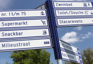 Signs at a lodge directing visitors to supermarket, snackbar, toilets, swimming pool, and activities.