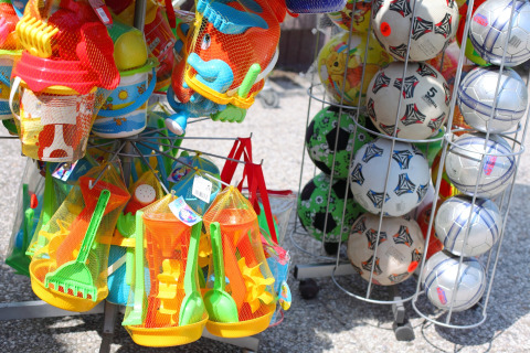 Set di giocattoli colorati e palloni da calcio esposti all’esterno di un lodge per bambini.