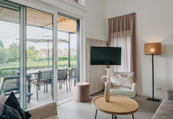Modern living room at Holiday Park Zeebad 12 in the Netherlands with terrace and outdoor dining area view.