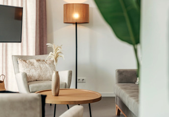 Modern lounge at Holiday Park Zeebad 12, Netherlands, featuring cozy armchairs, a lamp, and elegant decor.