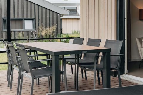 Udendørs spiseområde på en moderne terrasse ved Holiday Park Zeebad 12-lodge i Holland.