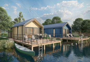 Lakefront lodges with decks, garden furniture, and a canoe at Holiday Park Klein Vink 24 in sunny weather.