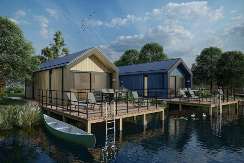 Feriehytter ved søen med terrasser, kano og havemøbler på Holiday Park Klein Vink 24 under blå himmel.