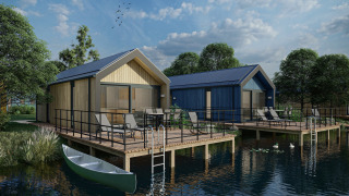 Cabañas junto al lago con terrazas, mobiliario de jardín y canoa en Holiday Park Klein Vink 24 en clima soleado.
