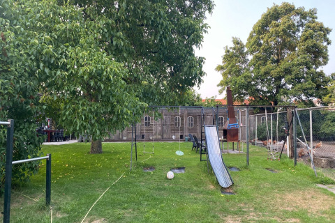 Parco giochi con altalene e scivolo accanto alla casa mobile Pipowagen «de Weideblick» in Olanda.