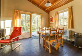 Hyggeligt spisestueområde i Holiday Home 5 Aarde Green Camping Lage Zwaluwe med store vinduer og naturudsigt.