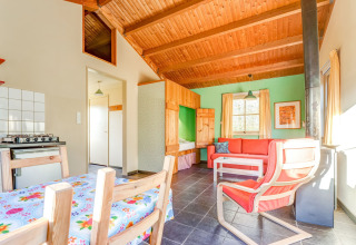 Bright interior of Holiday Home 5 Aarde Green Camping Lage Zwaluwe, Netherlands, with wooden ceiling and cozy sofa.