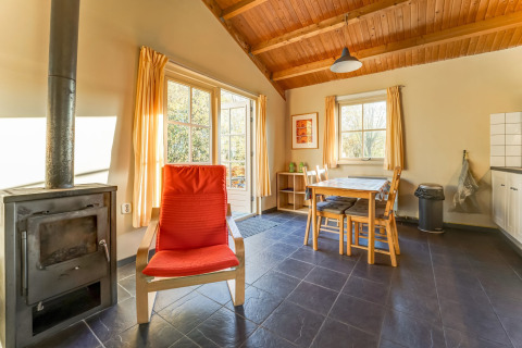 Helles Wohnzimmer im Holiday Home 5 Aarde Green Camping Lage Zwaluwe mit Ofen und Esstisch.