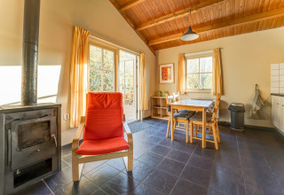 Helles Wohnzimmer im Holiday Home 5 Aarde Green Camping Lage Zwaluwe mit Ofen und Esstisch.