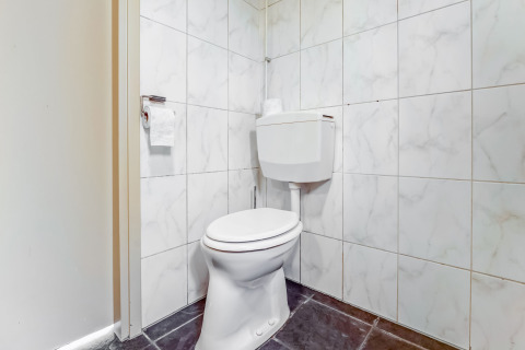 Toilet med hvidt sæde og flisevægge, fotograferet på Holiday Home «5 Aarde Green Camping Lage Zwaluwe», Holland.