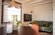 Interno di lodge moderno al Resort Gulpen 3 nei Paesi Bassi con divano verde e pareti in legno chiaro.
