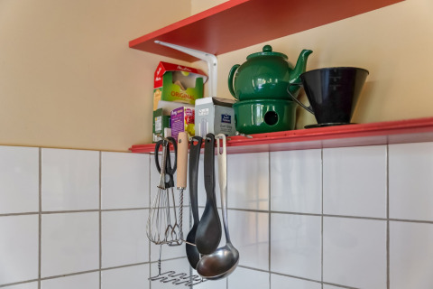 Küchenregal mit grüner Teekanne, Kaffeefilter, Teepackungen und Utensilien im Holiday Home 5 Aarde Green Camping Lage Zwaluwe.