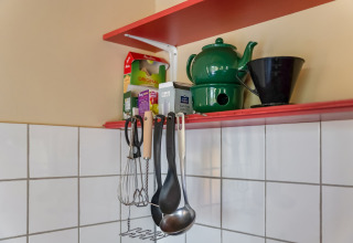 Køkkenhylde med grøn tekande, kaffefilterholder, teposer og redskaber i Holiday Home 5 Aarde Green Camping Lage Zwaluwe.