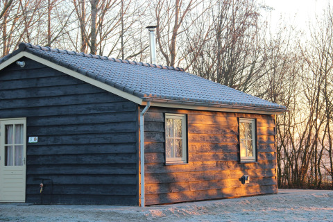 Cabaña de madera en Holiday Home 3 Aarde Green Camping Lage Zwaluwe, Países Bajos, en una mañana helada.