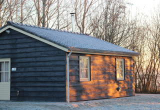 Blockhaus im Ferienhaus 3 Aarde Green Camping Lage Zwaluwe, Niederlande, bei Sonnenaufgang im Winter.