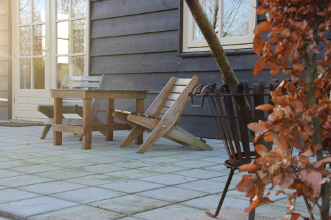 Terras aan Holiday Home «3 Aarde Green Camping Lage Zwaluwe» in Nederland met stoelen en tafel buiten.