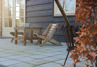 Terrazza alla Holiday Home «3 Aarde Green Camping Lage Zwaluwe» nei Paesi Bassi con sedie e tavolo.
